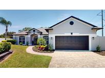 Charming single-story home featuring a well-manicured lawn, beautiful landscaping, and a two-car garage at 6198 Linneal Beach Dr, Apopka, FL 32703