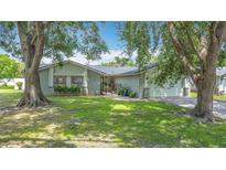Charming home with mature trees and green lawn in a peaceful residential neighborhood at 620 Wood Dr, Kissimmee, FL 34759