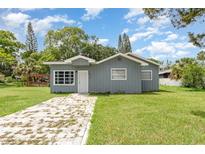 Charming single-story home with blue siding, a stone walkway and a well-manicured lawn at 660 6Th St, Daytona Beach, FL 32117