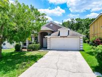 Charming home featuring a well-manicured lawn and a two-car garage in a lovely neighborhood at 6843 Cherry Grove Cir, Orlando, FL 32809
