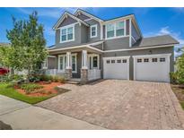 Beautiful two-story home with a three car garage, manicured lawn and brick paver driveway at 8230 Corkfield Ave, Orlando, FL 32832