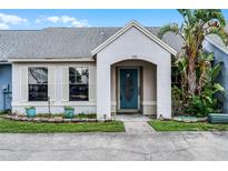 Inviting home exterior featuring a stucco facade, blue door, and lush landscaping at 116 Candlewick Ct, Sanford, FL 32771