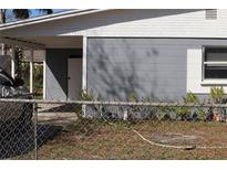 A exterior shot of a grey and white home, car parked beneath the carport at 1212 Leon Ln, Daytona Beach, FL 32117