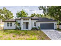 Beautifully renovated single-story home with a gray exterior, freshly landscaped yard, and a two-car garage at 1331 19Th St, Orlando, FL 32805