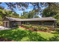 Exterior of a home with lush greenery, a well-maintained lawn, and a stone and siding facade at 1343 Charlotte St, Altamonte Springs, FL 32701
