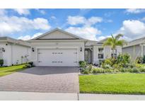 Charming single-story home featuring a brick driveway, two-car garage, and a lush landscaped yard at 1425 Lone Wood Blvd, Orlando, FL 32828