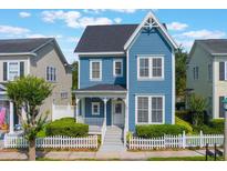 Charming two-story blue home with a inviting front porch and white picket fence at 181 Longview Ave, Kissimmee, FL 34747