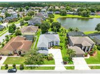 A neighborhood aerial view highlights a home with mature landscaping, a screened pool, and water view at 2214 Westbourne Dr, Oviedo, FL 32765