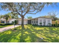 Charming single-story home featuring a lush lawn, mature tree, and brick accents, creating a welcoming curb appeal at 2520 Chanute Trl, Maitland, FL 32751