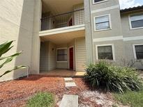 Inviting condo exterior with a second story balcony, covered entry, and landscaping at 3034 Parkway Blvd # 102, Kissimmee, FL 34747