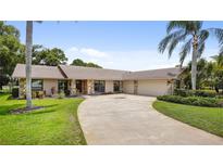 Charming single-story home boasts a stone accent facade, lush landscaping, and an extra-long driveway at 316 Cambridge Dr, Longwood, FL 32779