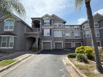 Attractive gray building exterior featuring multiple units and garage parking at 3391 S Kirkman Rd # 1236, Orlando, FL 32811