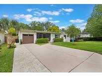 Charming single story home featuring a brown garage door, manicured lawn and lush green shrubbery at 3460 Fairway Ln, Orlando, FL 32804