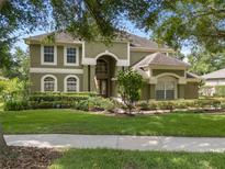 Charming two-story home with lush landscaping and a well-manicured lawn at 490 Wekiva Preserve Dr, Apopka, FL 32712