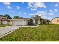 Charming single-story home with white exterior, attached garage and well-manicured lawn at 657 Mckinley Ct, Kissimmee, FL 34758