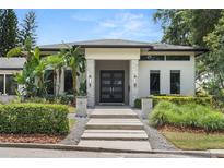 Contemporary home featuring a stylish walkway and modern front door framed by lush landscaping at 7 Ne Ivanhoe Blvd, Orlando, FL 32804