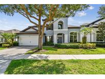 Charming two-story home featuring a well-manicured lawn, mature trees, and a two-car garage at 811 Sherbourne Cir, Lake Mary, FL 32746
