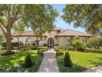 Charming home featuring a well manicured front yard, beautiful landscaping and a classic tile roof at 1010 Juliette Blvd, Mount Dora, FL 32757