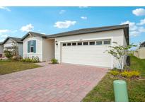 Charming single-story home featuring a two-car garage, manicured lawn and brick paved driveway at 1100 Griffon Ave, Lake Alfred, FL 33850