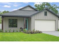 Charming single-story home featuring board and batten siding, a blue door and an attached garage at 1113 Naples Dr, Orlando, FL 32804