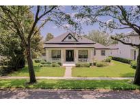 Charming one-story home features a welcoming front porch and lush landscaping at 11721 Camden Park Dr, Windermere, FL 34786
