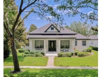 Charming single-story home featuring a well-manicured lawn, inviting front porch, and sophisticated black door at 11721 Camden Park Dr, Windermere, FL 34786