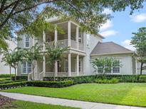 Charming two-story home featuring a double-decker front porch, beautiful landscaping and a manicured lawn at 1438 Stickley Ave, Celebration, FL 34747