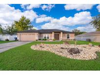Charming single-story home with well-manicured lawn and rock garden at 146 Hidden Pointe Ln, Groveland, FL 34736