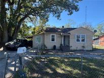 Charming bungalow-style home featuring a partially fenced yard, mature trees, and a covered parking area at 1500 43Rd St, Orlando, FL 32839