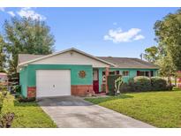 Charming single-story home with attached garage, colorful exterior paint, and well-maintained lawn at 1588 Alloway Dr, Deltona, FL 32738
