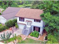Charming two-story home with a well-manicured front yard and a view of the serene lake in the background at 238 Lake Dr, Orlando, FL 32835