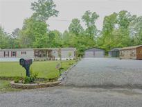 Charming mobile home featuring a gravel driveway, detached garage, and well-maintained lawn at 238 Lake Dr, Orlando, FL 32835