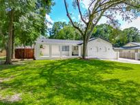 Inviting one-story home with a lush green lawn and mature trees providing shade at 3325 Horseshoe Dr, Longwood, FL 32779