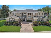 Elegant two-story home with stone accents, arched windows, and manicured landscaping at 3656 Heirloom Rose Pl, Oviedo, FL 32766