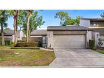Charming townhouse with a one-car garage and a well-maintained front yard with a privacy hedge at 411 Meadowood Blvd, Fern Park, FL 32730