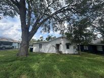 A view of the backyard and the back of the house featuring a large tree at 509 Lemon St, Auburndale, FL 33823