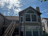 Condo exterior featuring stairs leading to the second floor, a chimney, and large windows at 652 Roaring Dr # 234, Altamonte Springs, FL 32714