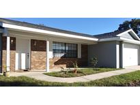 Charming single-story home featuring a brick facade, white trim, and a well-maintained front lawn at 943 Millenbeck Ave, Deltona, FL 32725