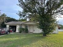 Charming single-story home featuring a cozy front yard and a convenient attached garage at 104 Corena Ct, Kissimmee, FL 34743