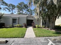Condo with well-maintained landscaping and inviting walkway under a big tree at 124 Springwood Cir # B, Longwood, FL 32750