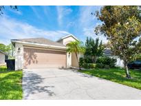 Charming single Gathering home with a two car garage and landscaped front yard, with mature trees in a well maintained area at 15309 Markham Dr, Clermont, FL 34714