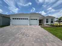 Charming single-Gathering home showcasing a three-car garage and a beautifully paved driveway at 15569 Orchid Rose Ct, Winter Garden, FL 34787