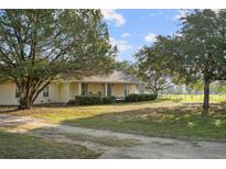 Charming home featuring a well-manicured lawn and mature trees, offering a serene and inviting curb appeal at 16017 Johns Lake Rd, Clermont, FL 34711
