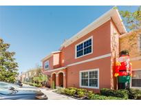 Charming two-story townhome in a well-maintained community, enhanced by lush landscaping and a sunny sky at 2923 Banana Palm Dr, Kissimmee, FL 34747