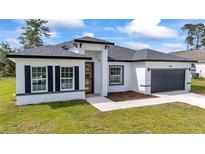 Beautiful exterior elevation of home featuring a gray roof and two car garage at 3211 Sw 128Th Street Rd, Ocala, FL 34473