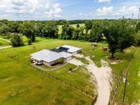 Expansive property featuring a home with a pool, surrounded by lush greenery and fenced pastures at 485 Nw 71St Ave, Ocala, FL 34482