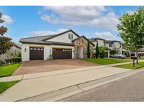 Beautiful home with a brick paved driveway and a two car garage, complimented by manicured landscaping at 7974 Chilton Dr, Orlando, FL 32836