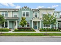 Charming townhome featuring a light green exterior, well-manicured landscaping, and welcoming front porch at 10221 Highline Crest St, Orlando, FL 32832