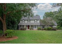 Charming two-story home features a well-maintained lawn and a welcoming front porch at 104 Forest Point Ln, Longwood, FL 32779