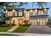 Modern two-story home with a manicured lawn, stone walkway with lights, and a two-car garage at 1211 Munster St, Orlando, FL 32803